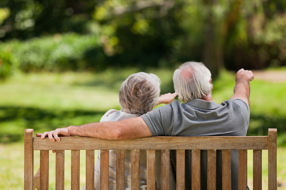 Couple sitting on the bench  with their back to the camera Couple sitting on the bench  with their back to the camera